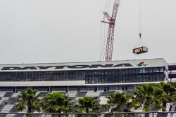 A crane takes away the first piece of the Daytona press box and suite facility