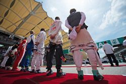 The drivers observe the national anthem on the grid