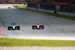 Lewis Hamilton, Mercedes AMG F1 W06, dan Sebastian Vettel, Ferrari SF15-T battle for the memimpin of