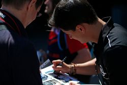 Julian Leal, Carlin, signs a photo for a fan