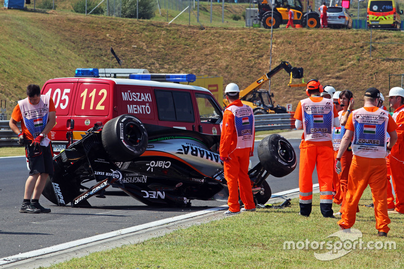 Safety crews tend to the crashed car of Sergio Perez, Sahara Force India F1