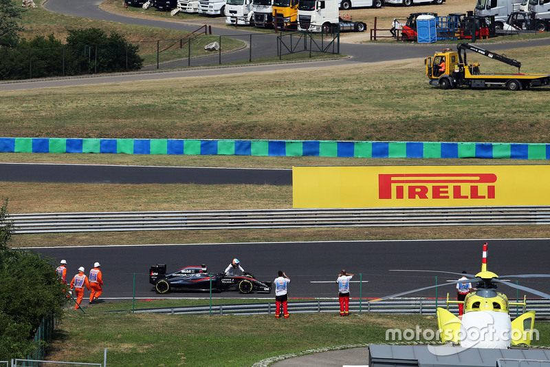 Fernando Alonso, pushes his McLaren MP4-30 into the pit lane during qualifying