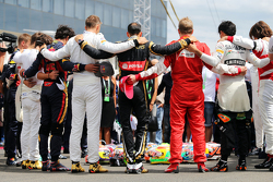 The drivers observe the tribute to Jules Bianchi on the grid