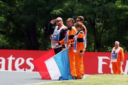 Marshals observe the pre-race tribute to Jules Bianchi