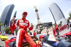 Esteban Gutiérrez con una bandera de México festeja en la columna del Angel de la Independencia durante Scuderia Ferrari Street Demo en la Ciudad de México
