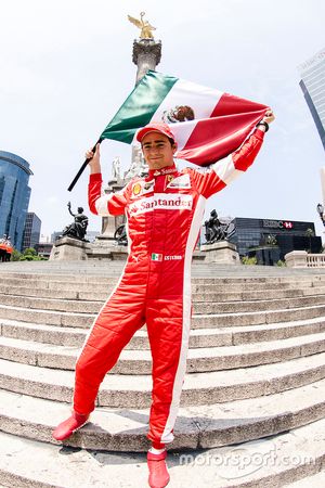 Esteban Gutiérrez con una bandera de México festeja en la columna del Angel de la Independencia dura