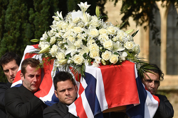 Mark Webber and Dario Franchitti help carry the casket of Justin Wilson during funeral proceedings