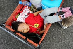 A young fan sleeps in a trolley