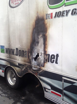 The burned hauler of Jimmy Means Racing carrying the car of Joey Gase