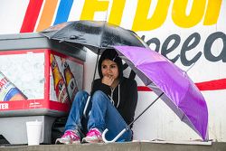 Una aficionada se cubre de la lluvia en las tribunas