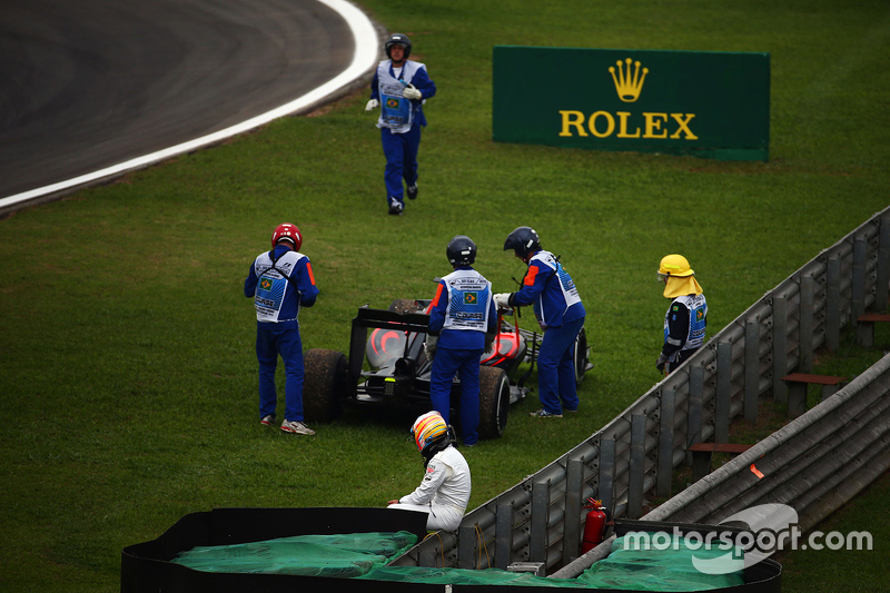 Fernando Alonso, McLaren assiste a remoção da sua McLaren MP4-30 da pista