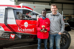 Romain Dumas and Samba, a Senegalese boy who was saved thanks to Mécénat Chirurgie Cardiaque, with the Peugeot 2008 DKR15+