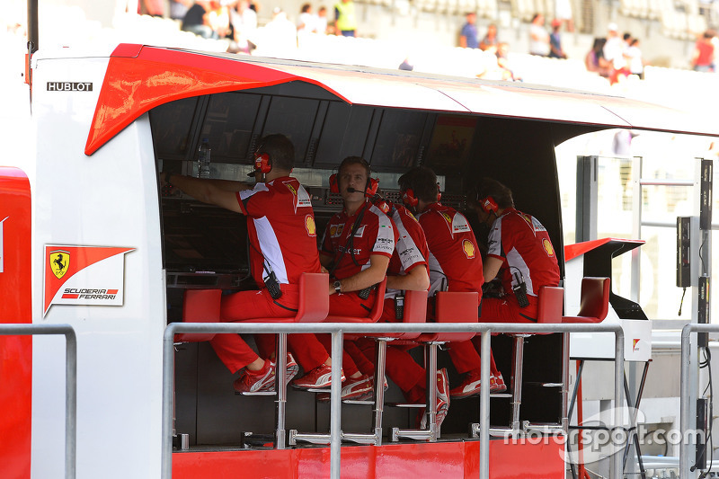 Ferrari team members on the pit wall