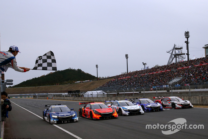 Takuma Sato zwaait de zwart-wit geblokte vlag voor de Super GT Honda-deelnemers