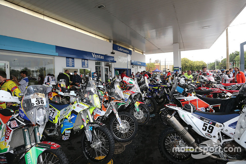 El convoy de motos y quads convoy se detiene en una estación de gasolina.