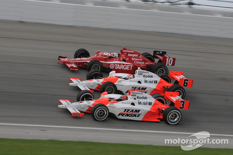 Helio Castroneves, Ryan Briscoe, and Dan Wheldon run three wide