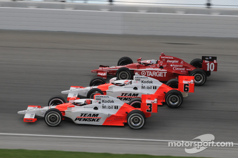 Helio Castroneves, Ryan Briscoe, and Dan Wheldon run three wide