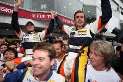 Race winner Fernando Alonso celebrates with Nelson A. Piquet and Renault F1 team members