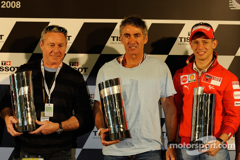 Casey Stoner recibe su versión réplica del trofeo de primera clase en reconocimiento a su campeonato del mundo 2007 y posa con Wayne Gardner y Mick Doohan