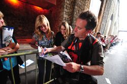 Motorsport.com's Eric Gilbert signs an autograph for a young fan