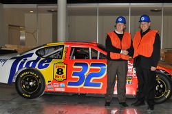 En el Salón de la Fama, Ricky Craven y el dueño de equipo, Cal Wells posan con el Pontiac que Craven llevó al triunfo en el Darlington Raceway en 2003 en el cierre más apretado en la historia de NASCAR