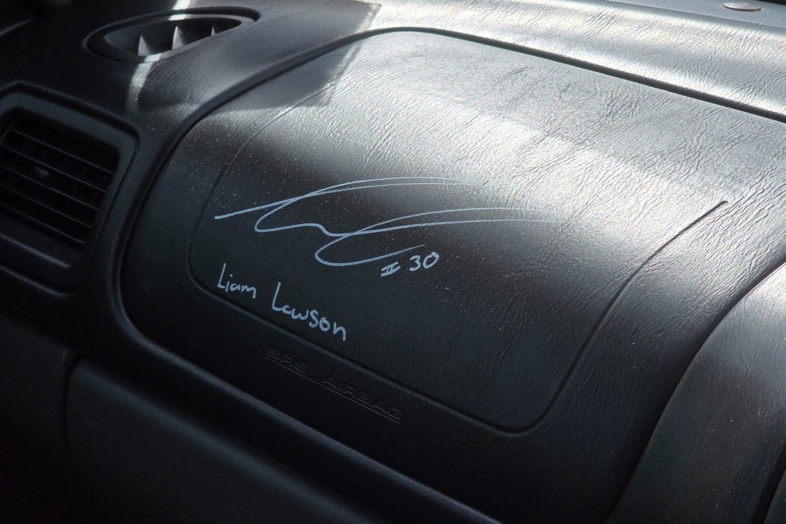 Liam Lawson has signed the dashboard of the Subaru Forester