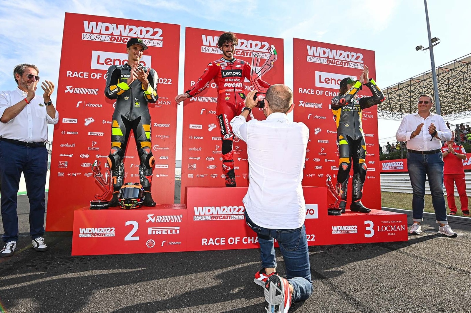 Claudio Domenicali, CEO de Ducati, fotografia el podio de la WDW2022, con Bagnaia, Marini y Bezzecchi