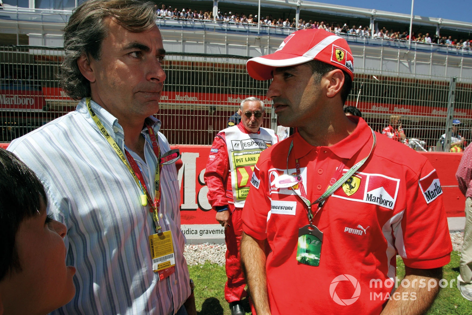 Carlos Sainz Sr and Carlos Sainz Jr speaking to Ferrari test driver Marc Gene at the 2005 Spanish GP