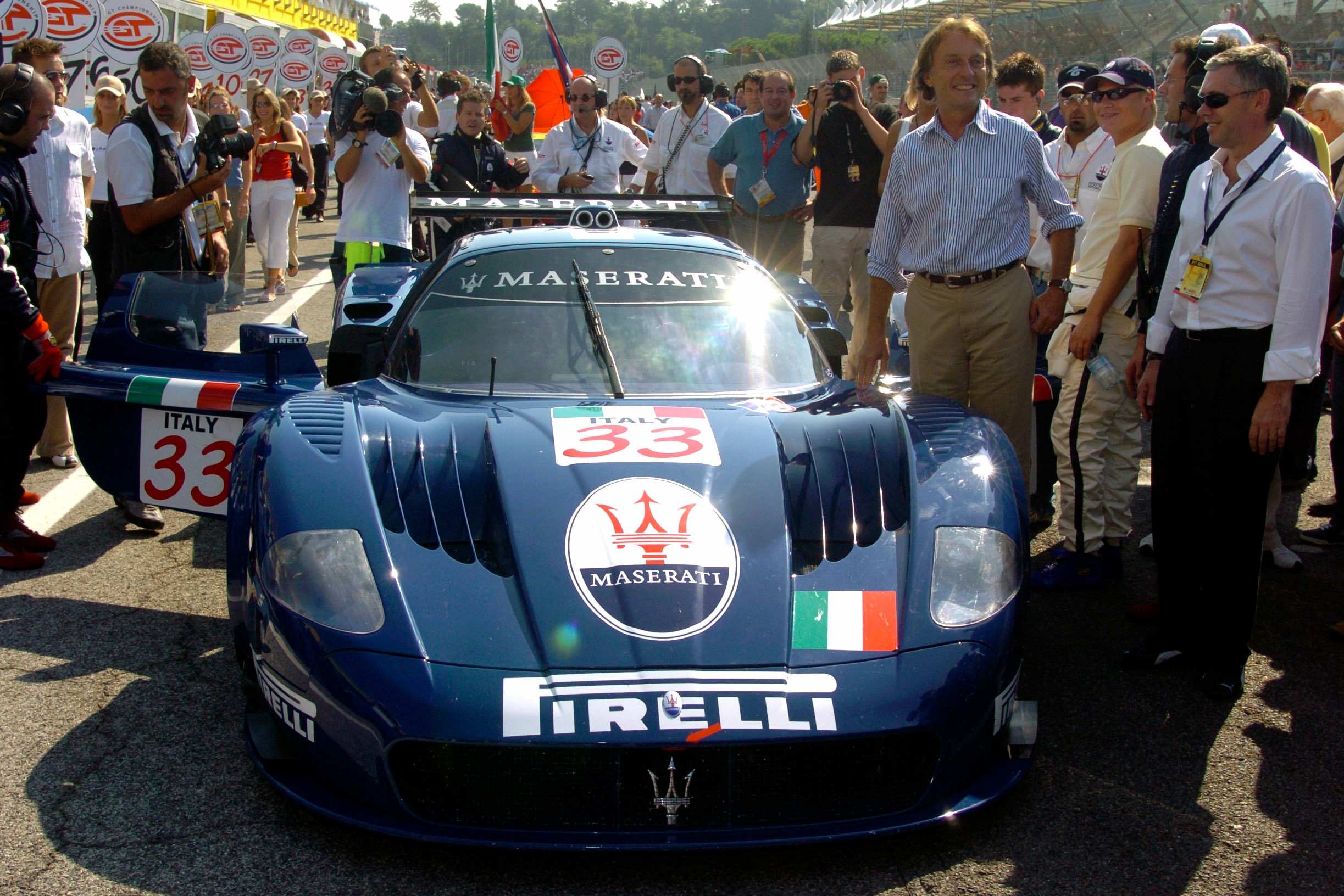 Ferrari chairman de Montezemolo smiles for the cameras before the MC12's competition debut at Imola in 2004